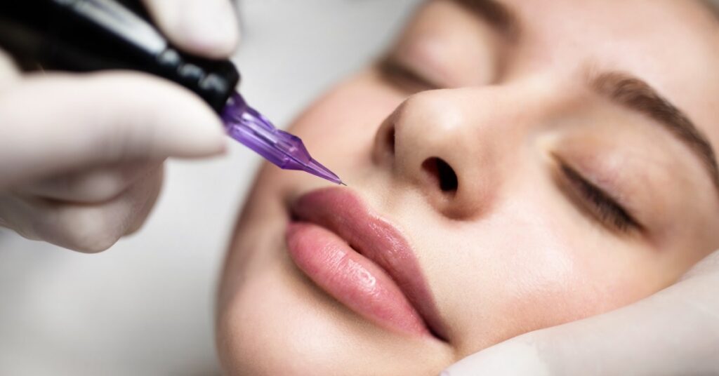 A woman laying down with her eyes closed receiving a lip blush procedure from the gloved hands of a professional.